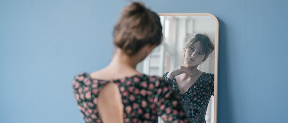 Woman looks thoughtfully in the mirror and is unlucky in love