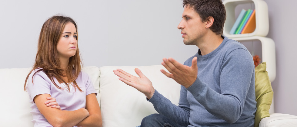 Upset woman talking to a frustrated man on a couch
