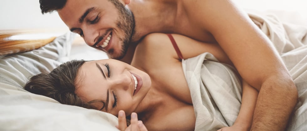 A young couple being playful in bed in the morning