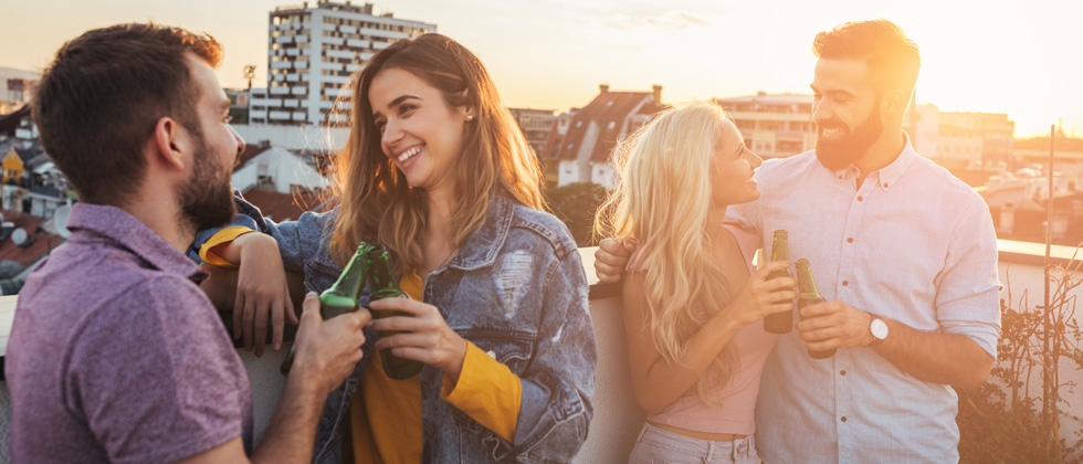 Two couples standing on a roof top talking to their partners