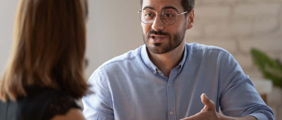 A man trying to tell the woman he's sitting with something
