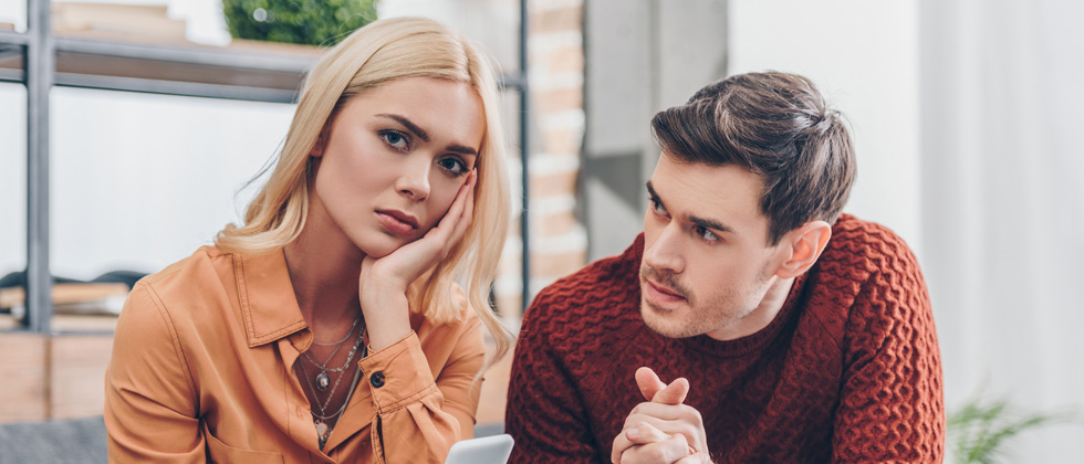 A couple sitting and having a serious conversation looking worried
