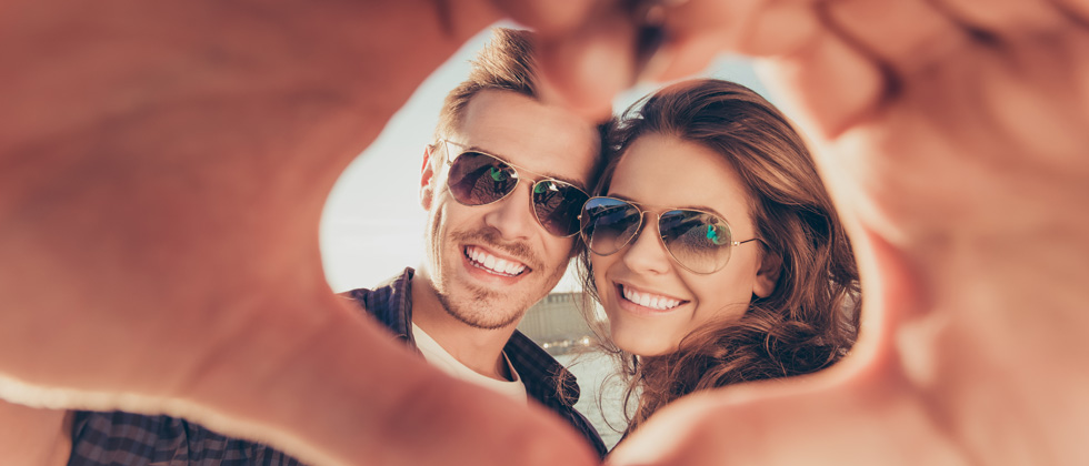 Couple taking a picture of their hands forming a heart around them