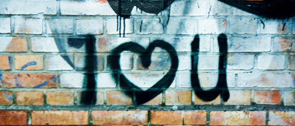 A brick wall with graffiti that says I LOVE YOU