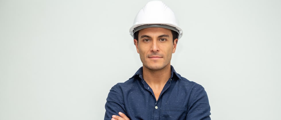 Man wearing a hard hat looking serious into the camera
