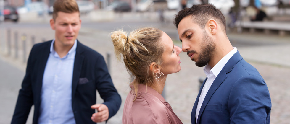 A couple about to kiss while someone tries to interrupt