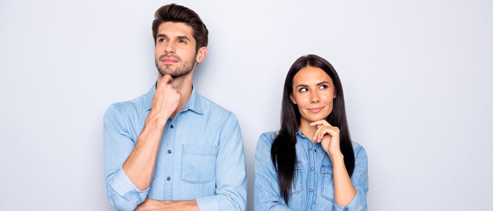 A couple standing looking suspicious - both looking in opposite directions