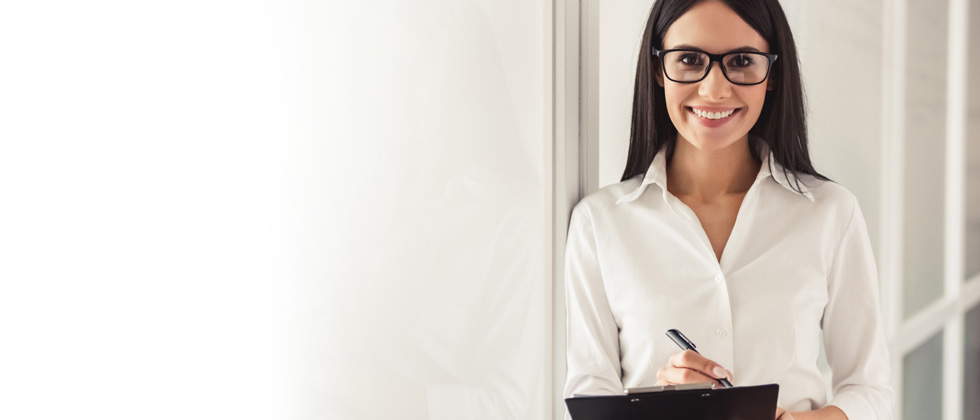 A professional woman smiling with a notepad