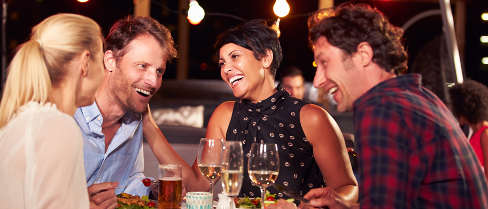 Two couples on a double date enjoying dinner & drinks