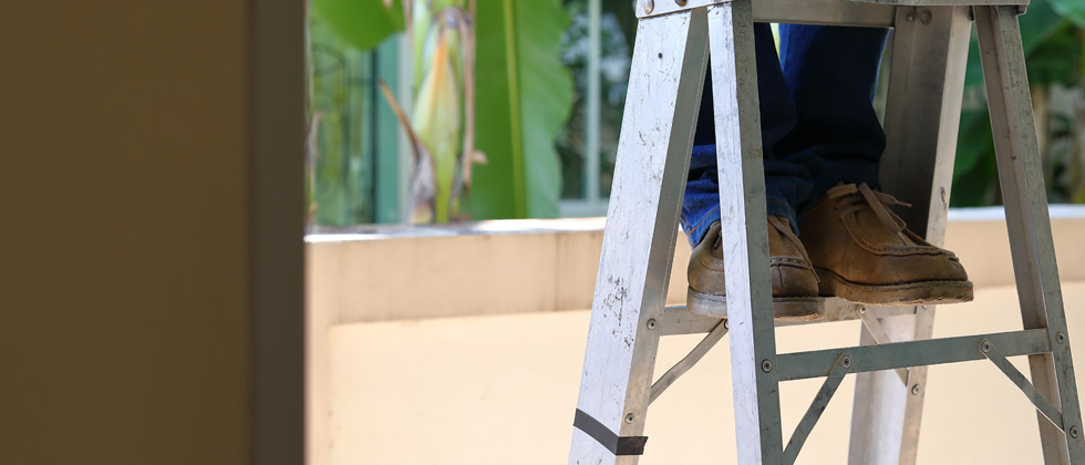 Someone standing at the top of a ladder