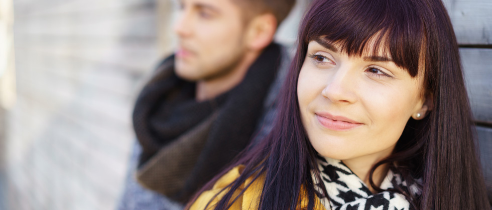 A couple standing together with the woman smiling into the camera's focus