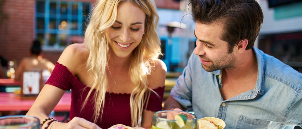 Couple smiling and eating on a lunch date