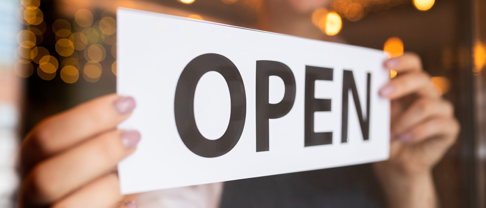 A sign being put up that says OPEN