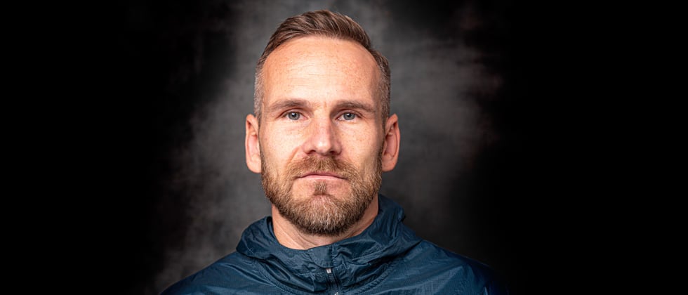 Bearded man looking directly into the camera with intense blue eyes