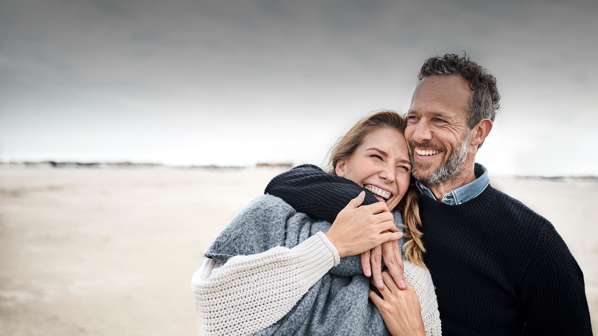 Dating after 40 symbolized by a man who strolls happily with his date at the beach