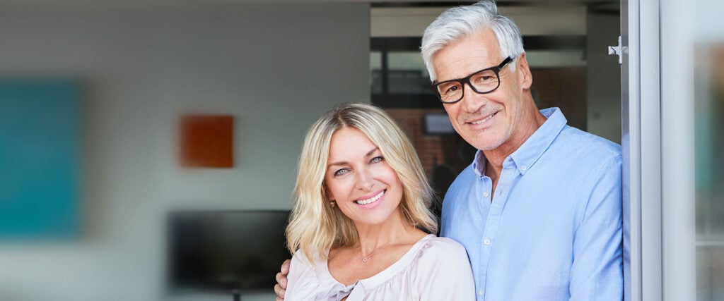 Casal de idosos sorrindo para a câmera como um símbolo de namoro sênior