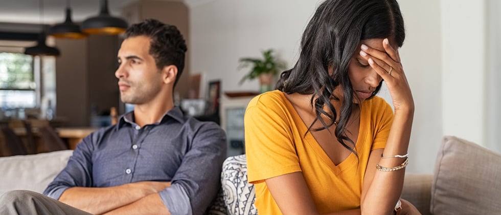 Young couple sitting together looking detached from one another