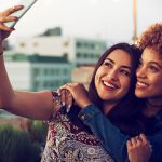 Lesbian dating illustrated by two women who embrace each other and take a selfie