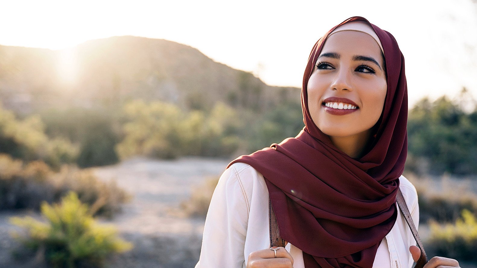 Woman looking happily at camera, symbolizing Muslim dating