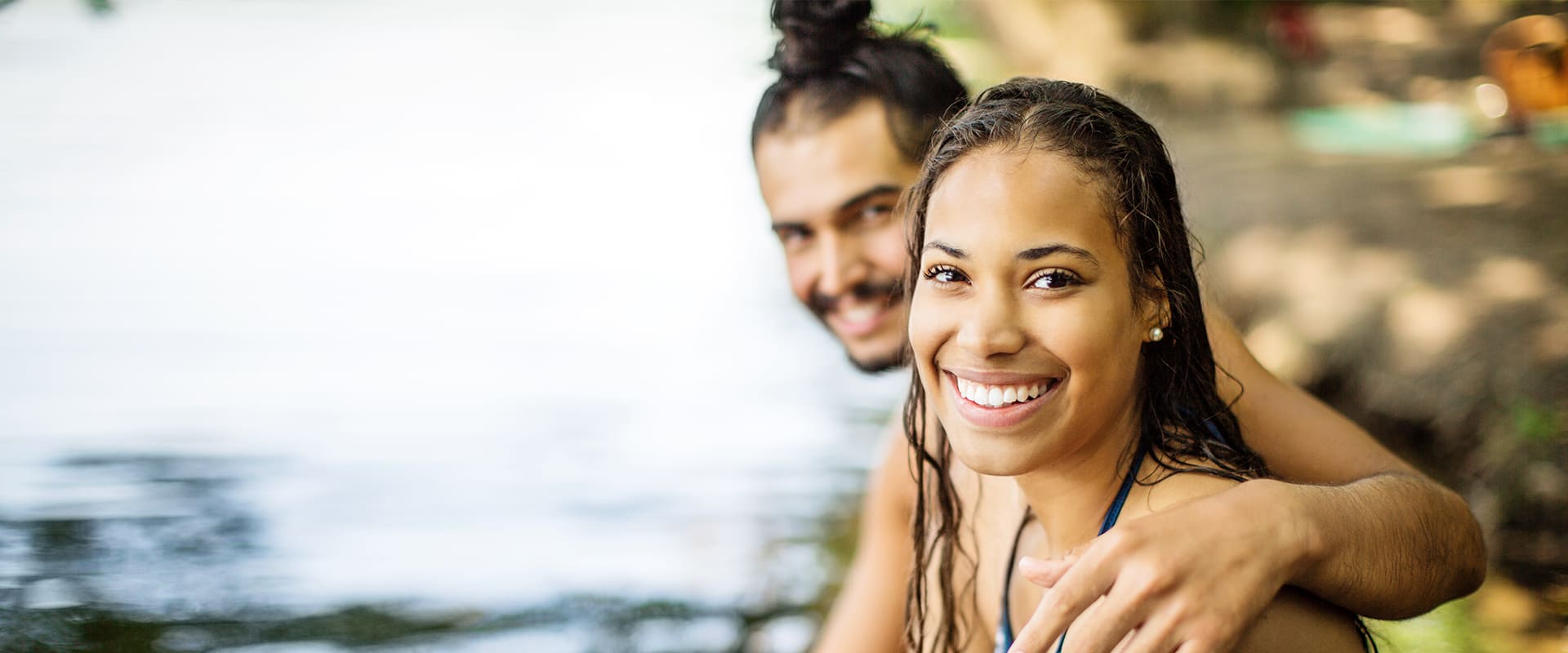 Latin couple hugs and smiles at the camera