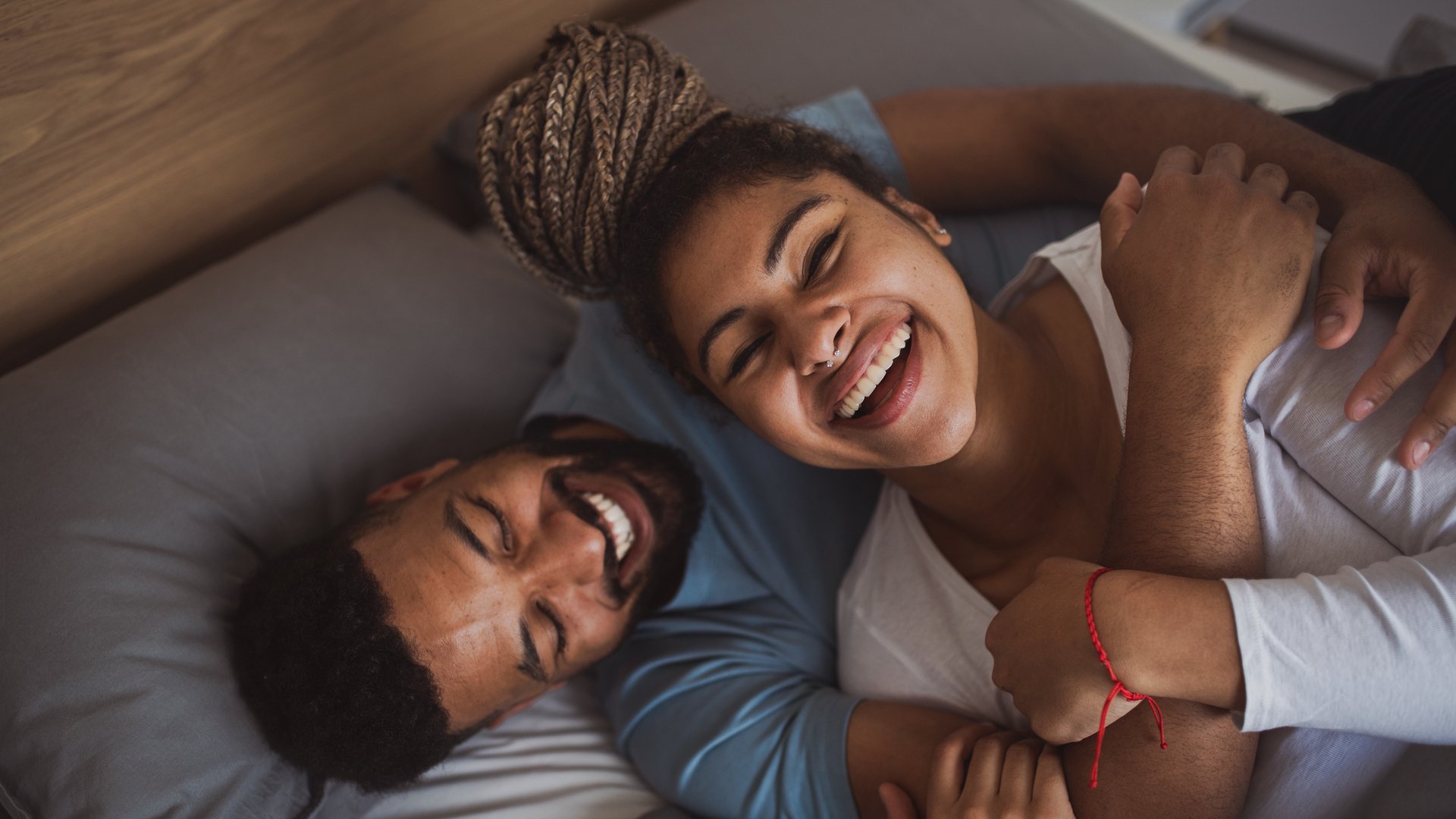 Laughing couple laying in bed.