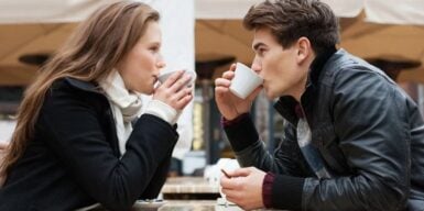 Man and woman on a coffee date look into each other's eyes