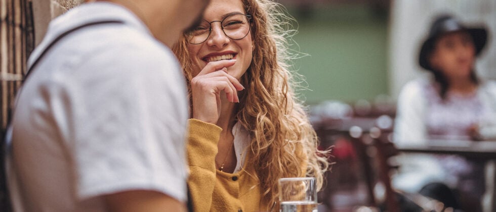 Woman smiles at man as example of good conversation starter with women