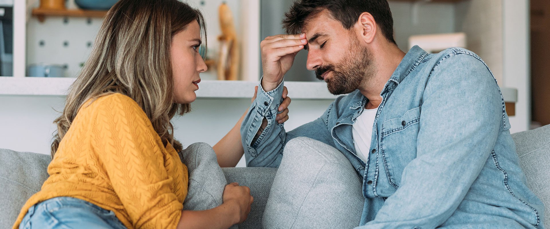 Man and woman sitting on sofa and man looking thoughtful as symbol for dating after divorce