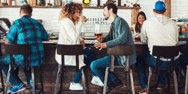 Man and woman sitting together in a bar and talking as symbol for dating rules