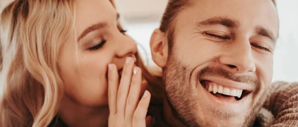 Woman whispers in man's ear as example of how to deal with mixed signals
