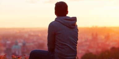 Man sits facing the city and you see only the outline of his body as a symbol for when you are ghosted