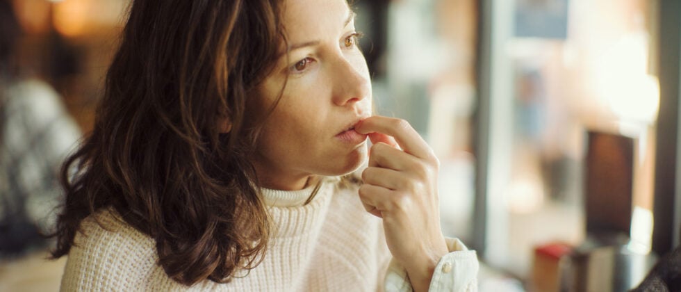 Woman looks thoughtful and wonders how to choose between two guys