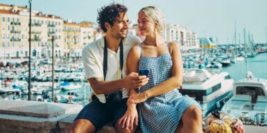 Man and woman sitting together at the harbor looking at each other as a symbol of how to get a boyfriend