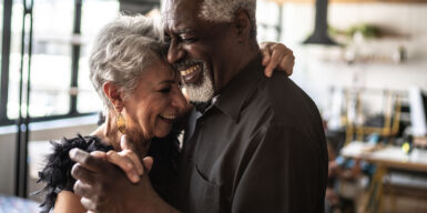 Older couple lie in each other arms and laugh as symbol what is love