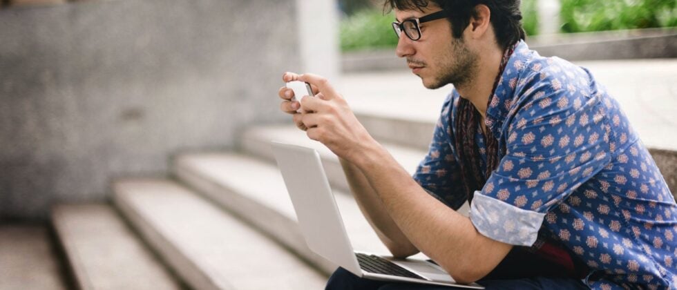 Man sitting on stairs with laptop and cell phone as symbol why ghosters always come back