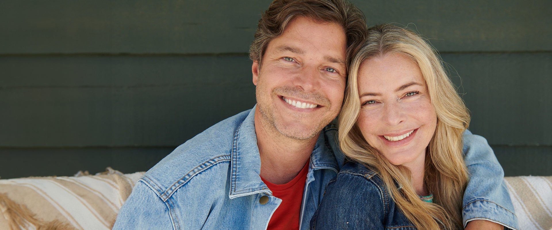 Woman and man over 50 smiling into camera as a couple