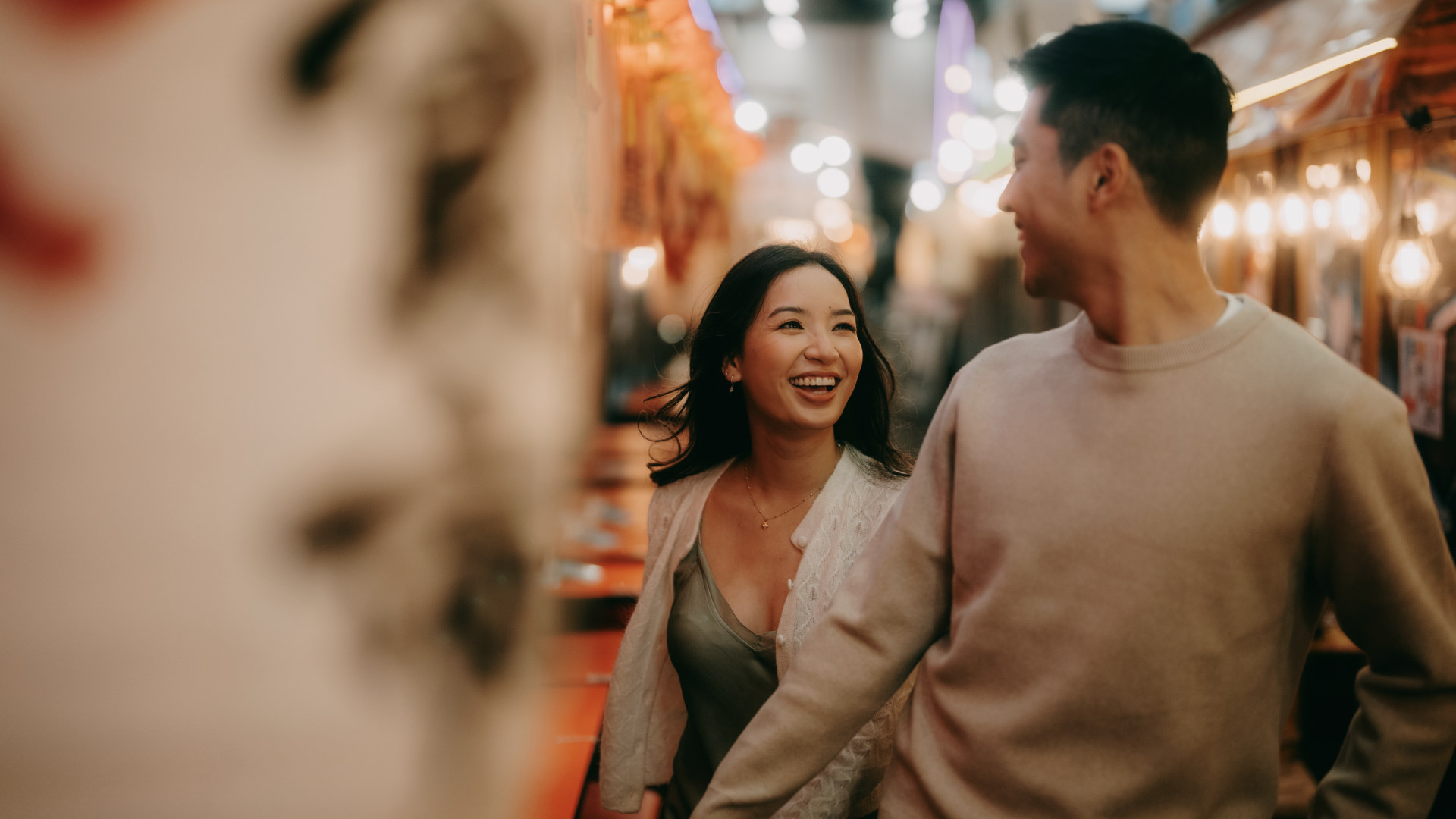 A woman and a man are walking together and laughing, symbolizing asian dating