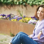 Woman sitting and smiling as a symbol of free dating with eharmony