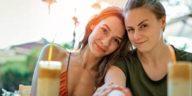 Two woman smiling in camera as symbol for lesbian relationship