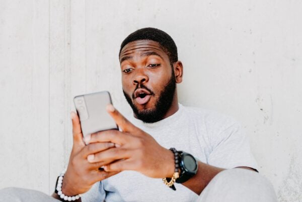 a man looks at his phone in surprise.