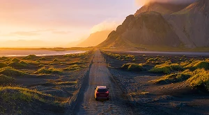 A car driving into the sunset