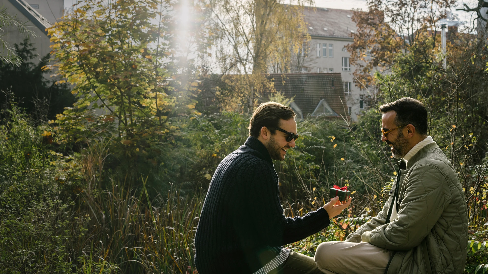 A couple is sitting together in the backyard of a house in Dallas, having a conversation.