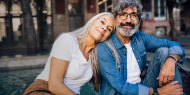A woman and a man over 50 sitting next to each other.