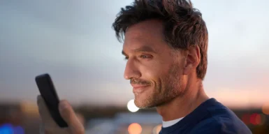 Man on his phone in front of a sunset